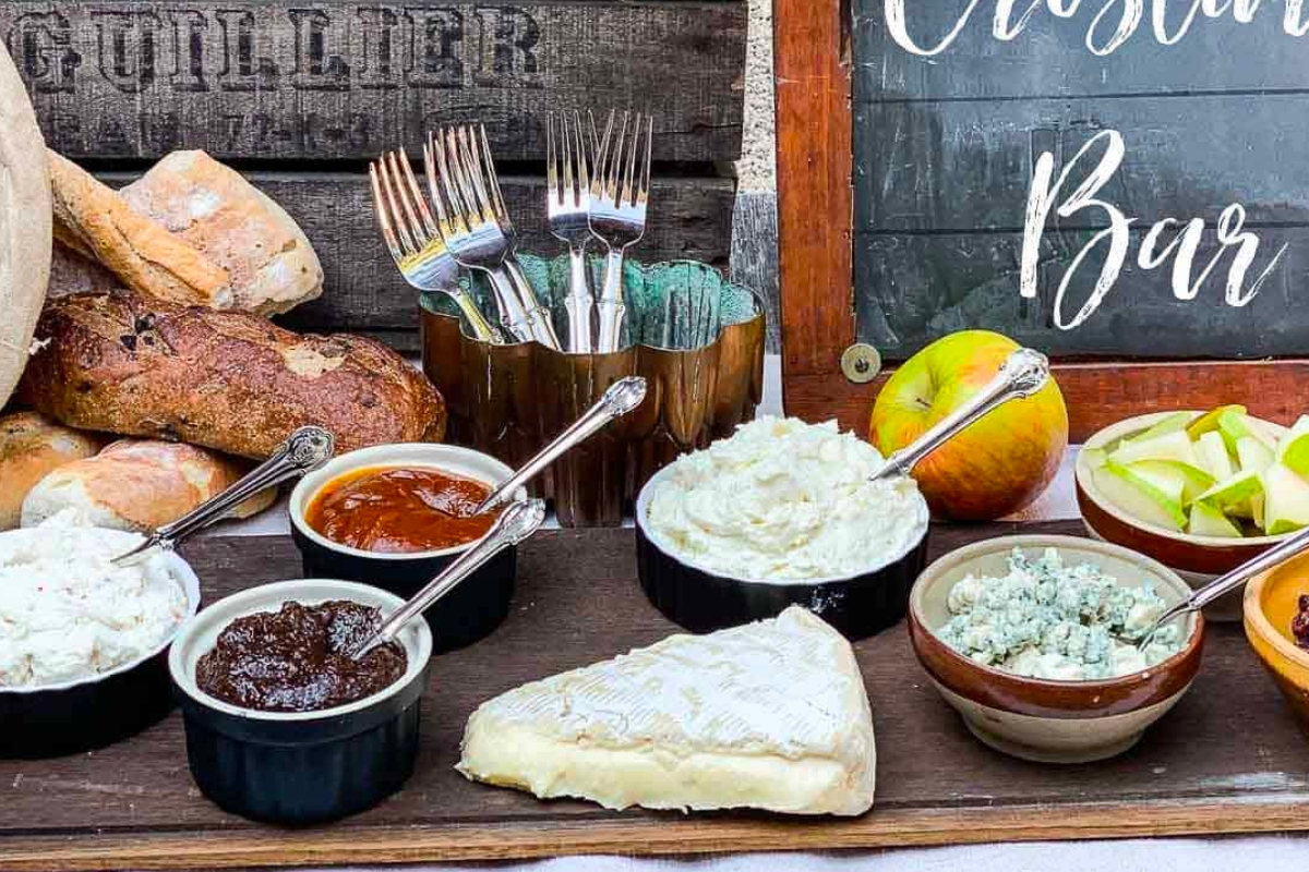 A cheese and charcuterie bar with a sign, serving Goat Cheese appetizers.