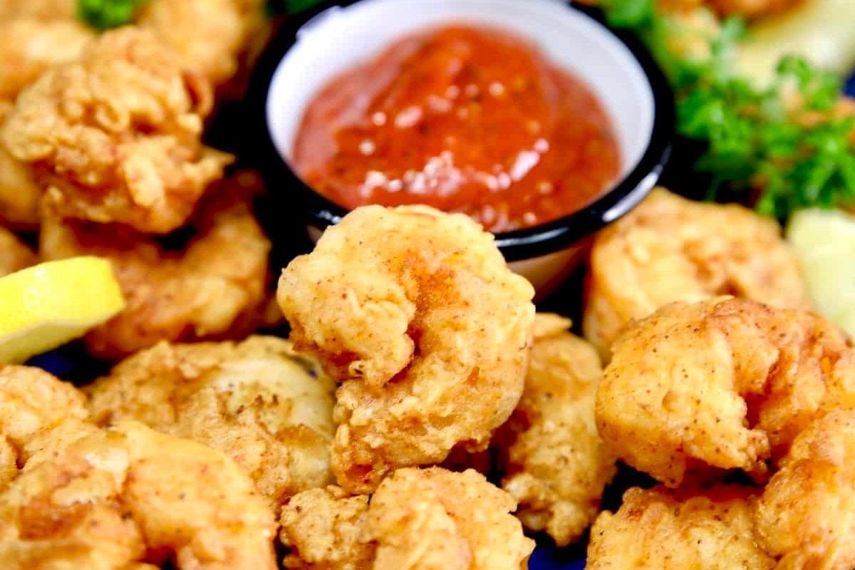 Delicious fried shrimp served with a flavorful dipping sauce on a plate, perfect for dinner.