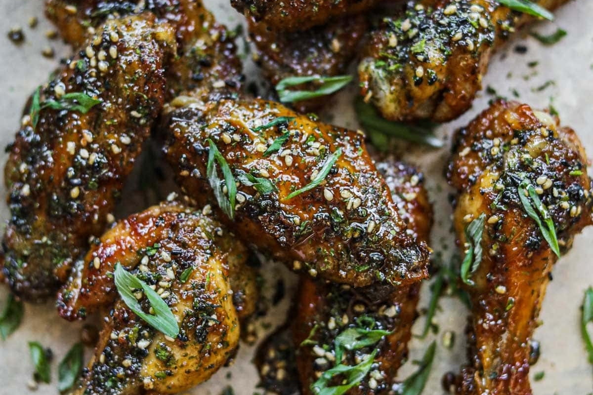 Game day chicken wings with herbs and spices on a baking sheet.