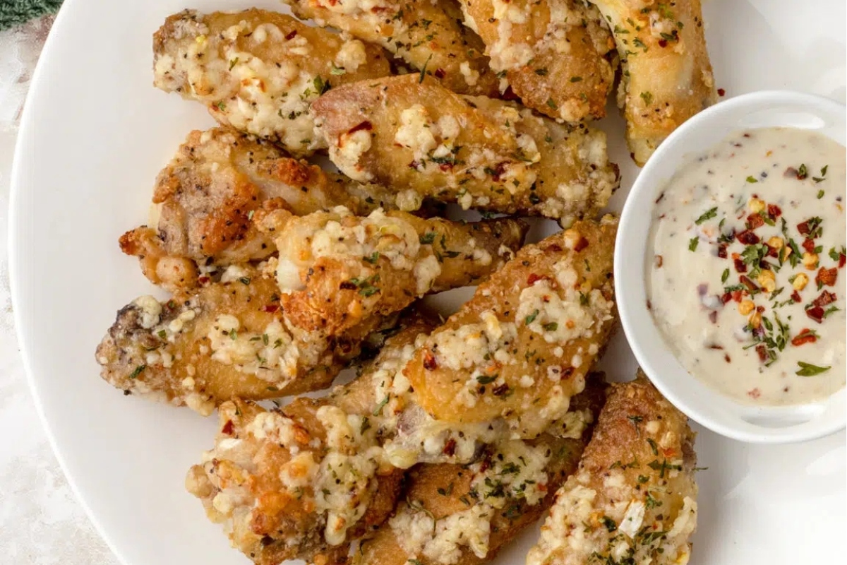 Game day main dishes featuring chicken wings with a dip, served on a white plate.
