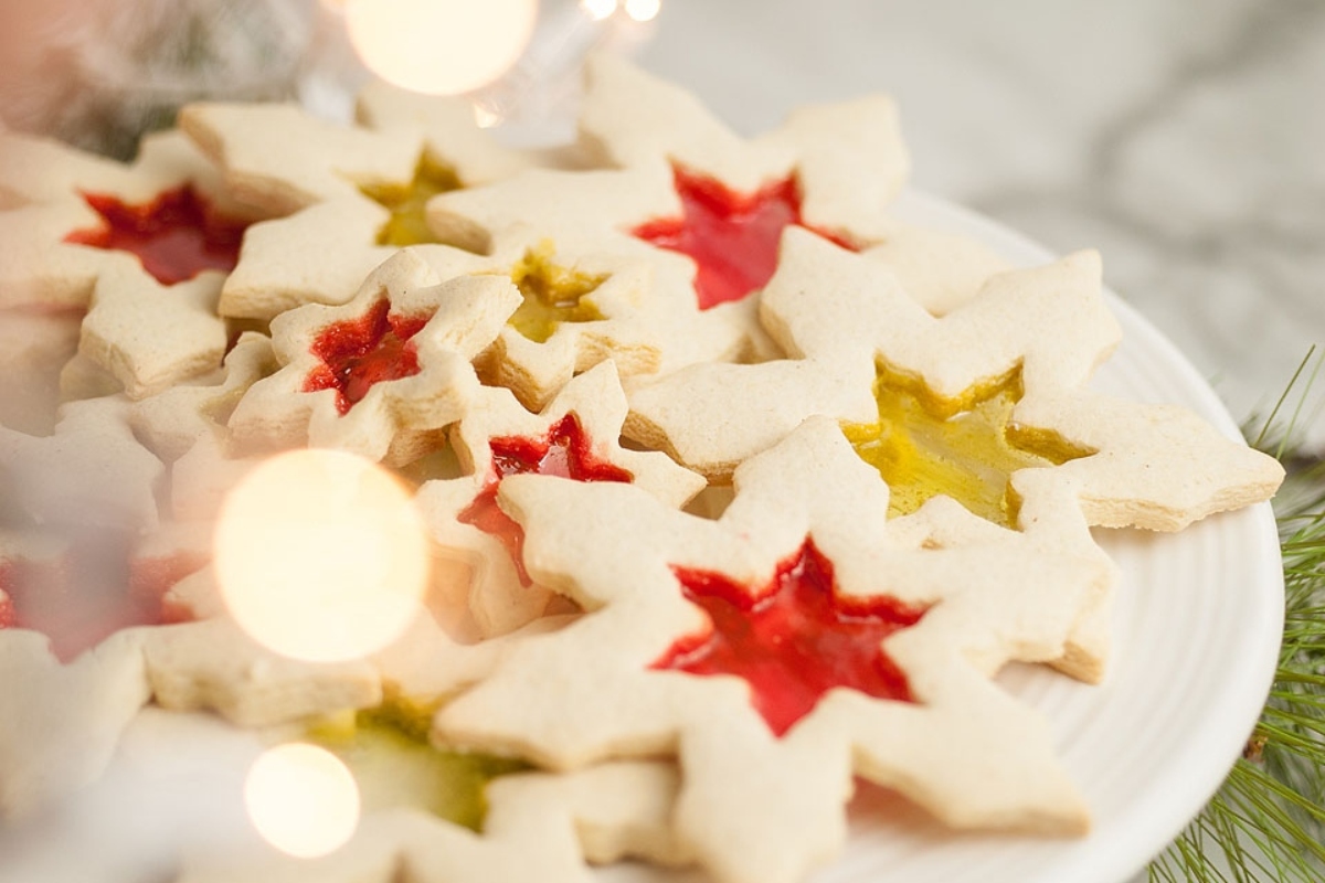 A plate of Christmas gingerbread cookies with jelly icing on it.