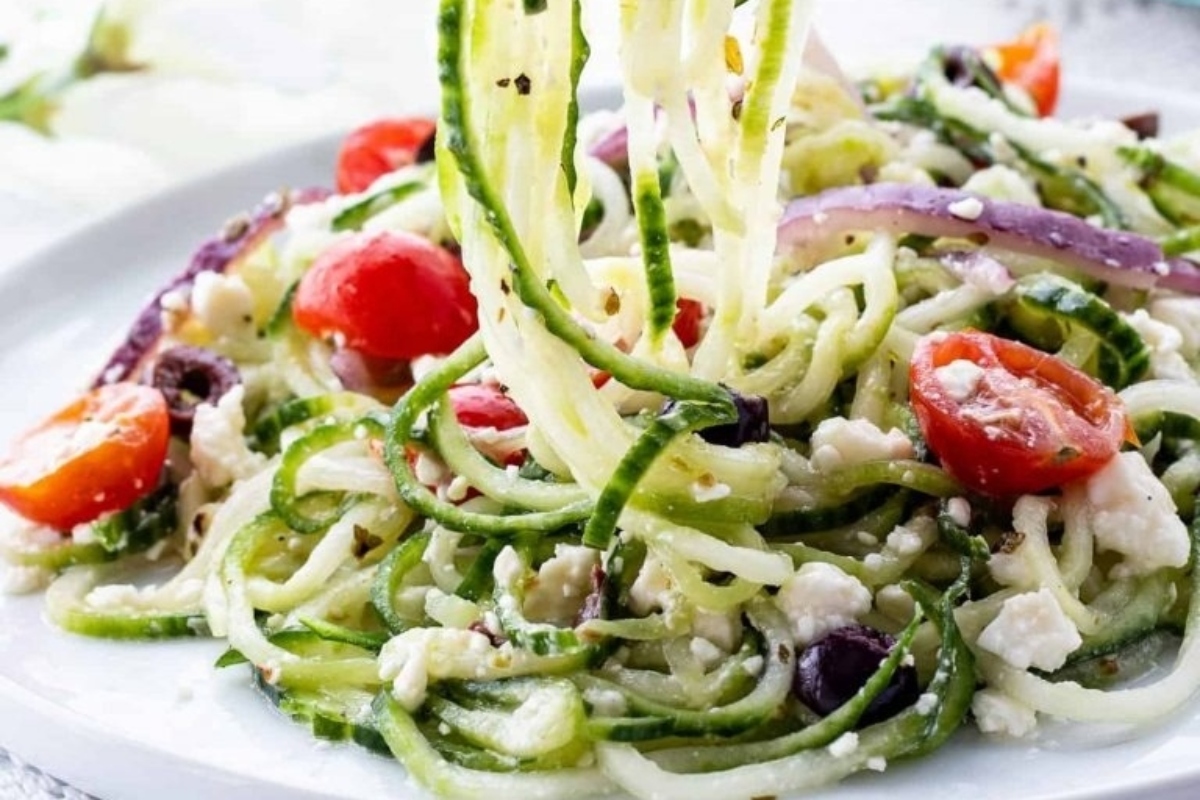Spiralized zucchini salad with feta cheese and tomatoes on a plate.