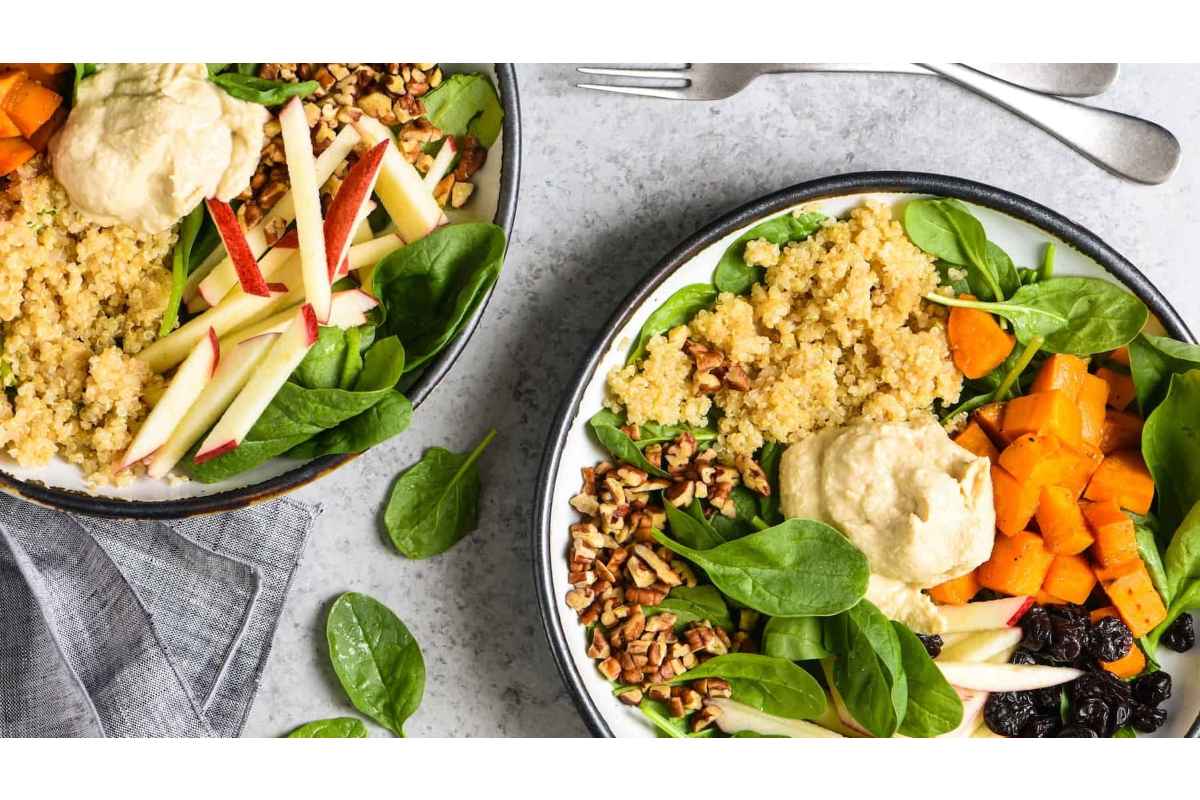 Two healthy bowls of salad with quinoa, carrots, and spinach - perfect for high protein lunches!