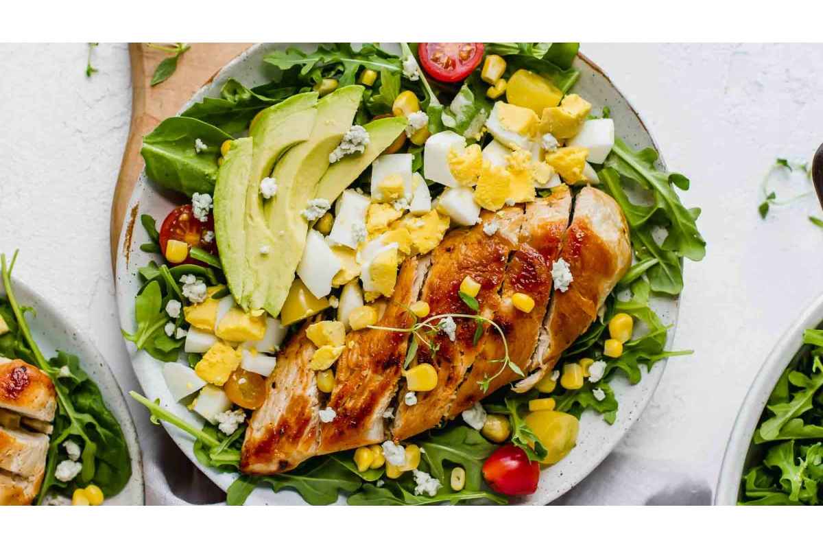 A high protein lunch option, this healthy plate features a delicious chicken salad with avocado, tomatoes and greens.