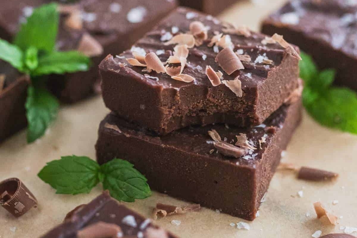 A stack of chocolate fudge with mint leaves on top, perfect for peppermint recipes.