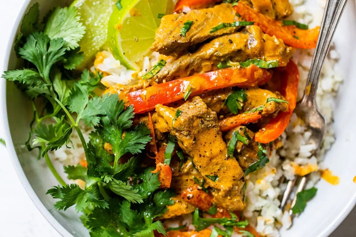 Thai beef curry with peppers and lime in a grain bowl.