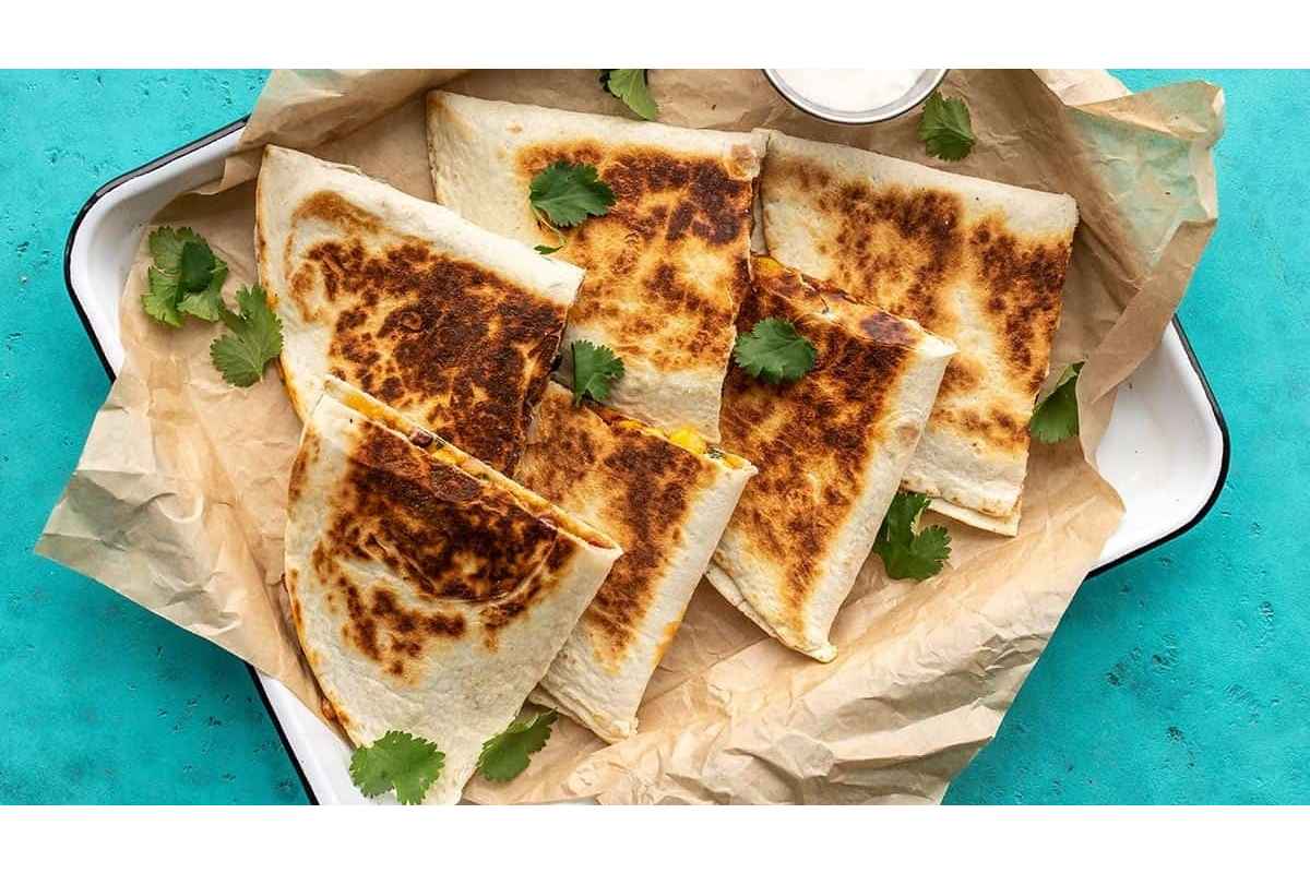 High protein quesadillas on a plate with a bowl of guacamole, perfect for a healthy lunch option.