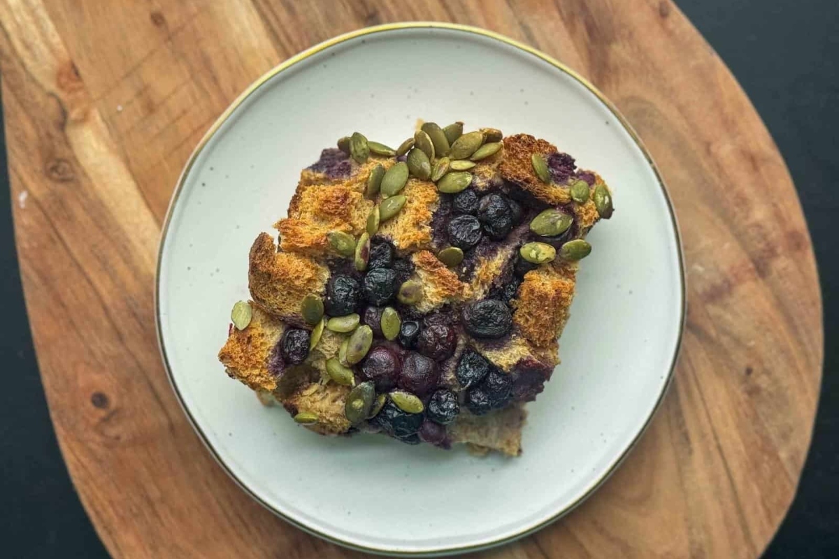 A high protein breakfast consisting of a plate of bread topped with blueberries and nuts for a healthy start to the day.