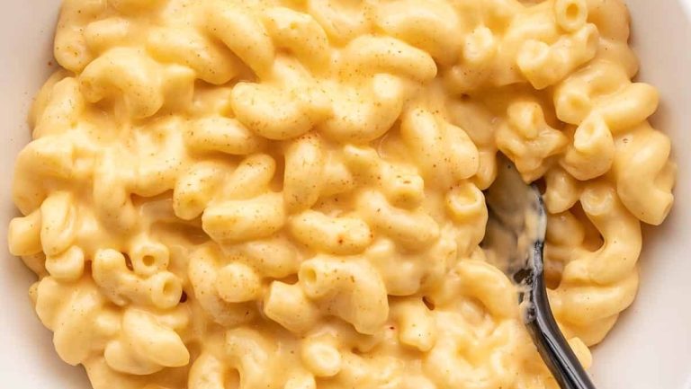 Macaroni and cheese, a delicious side dish, served in a white bowl.