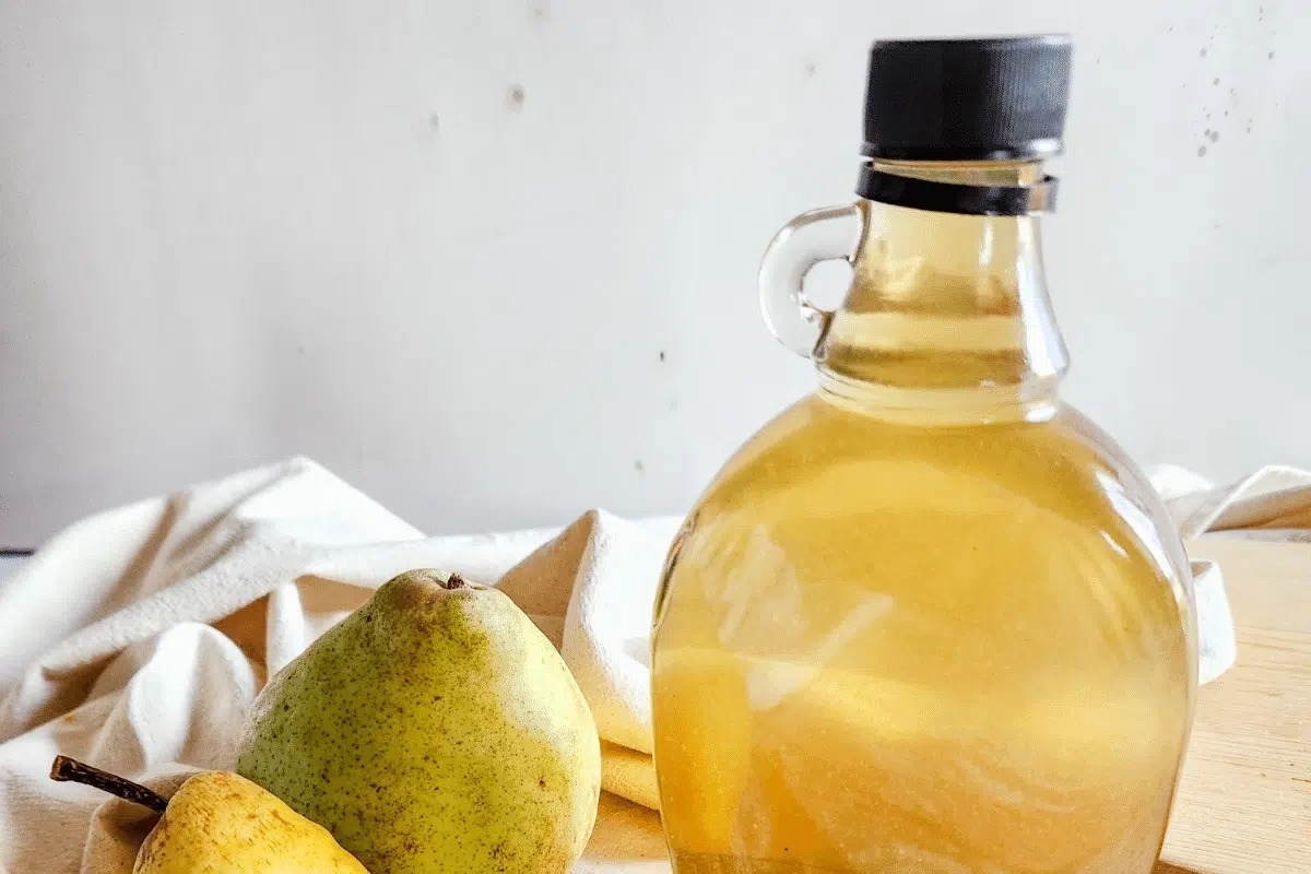 A jar of pears and a wooden cutting board.