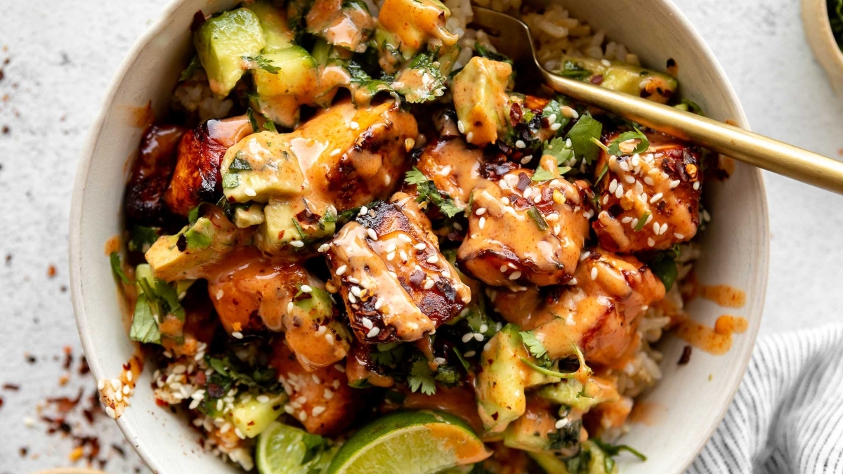 A bowl of chicken and rice with avocado sauce, perfect for dinners.