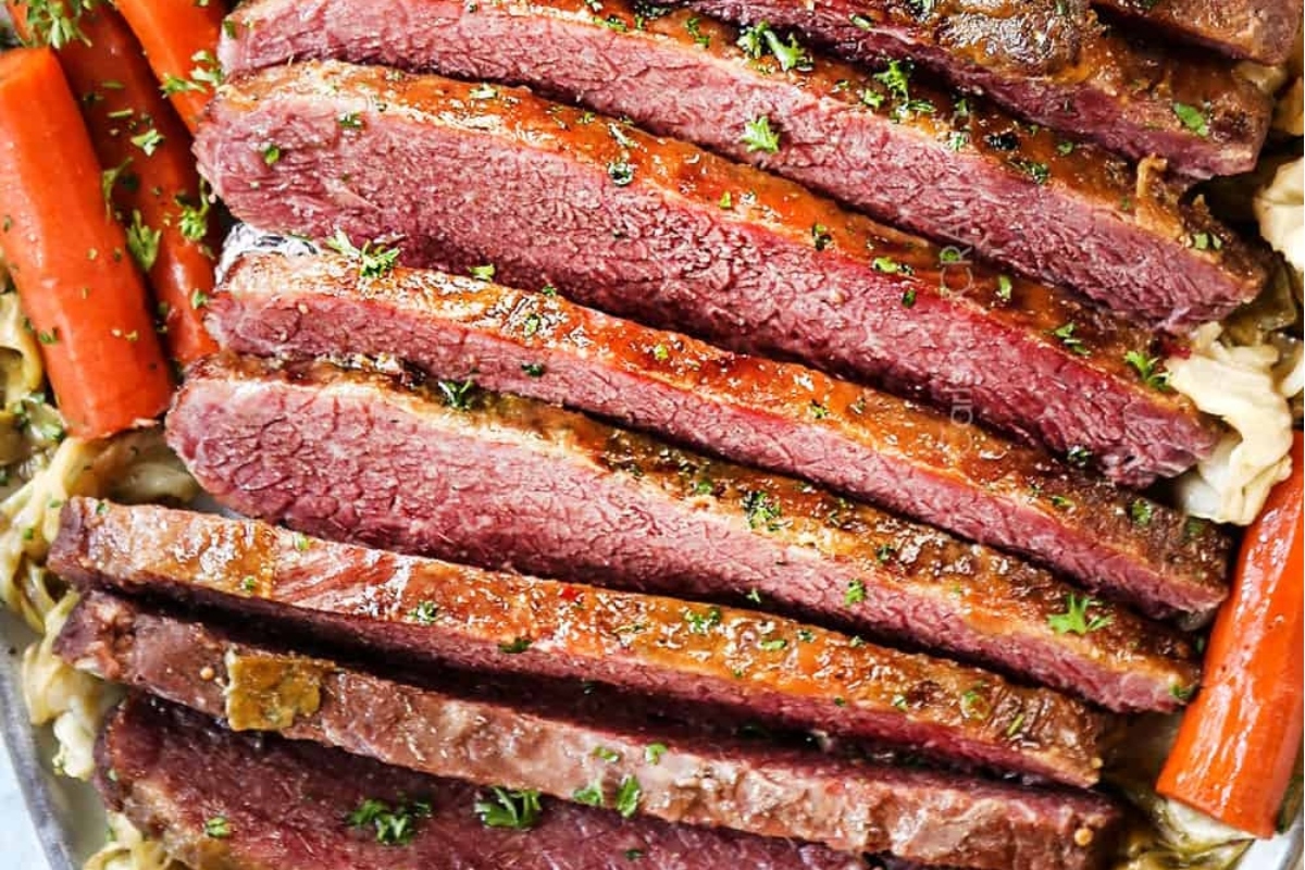 Christmas dinner with sliced corned beef and carrots in a baking dish.