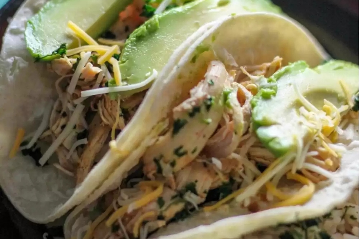 Taco Night Chicken Tacos: Freshly made with succulent chicken, creamy avocado, and fragrant cilantro. Served on a plate for a delightful dinner experience.