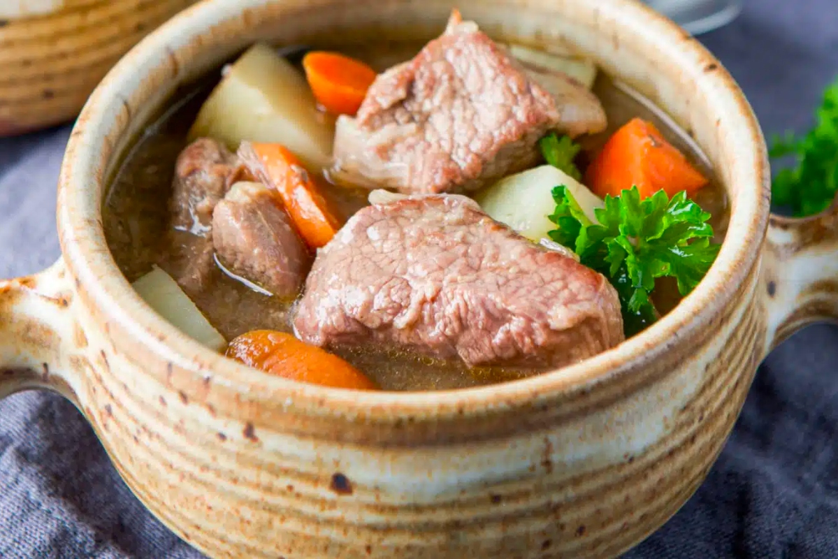 Cook a delicious Irish beef stew in an Instant Pot with tender carrots and garnish with parsley.