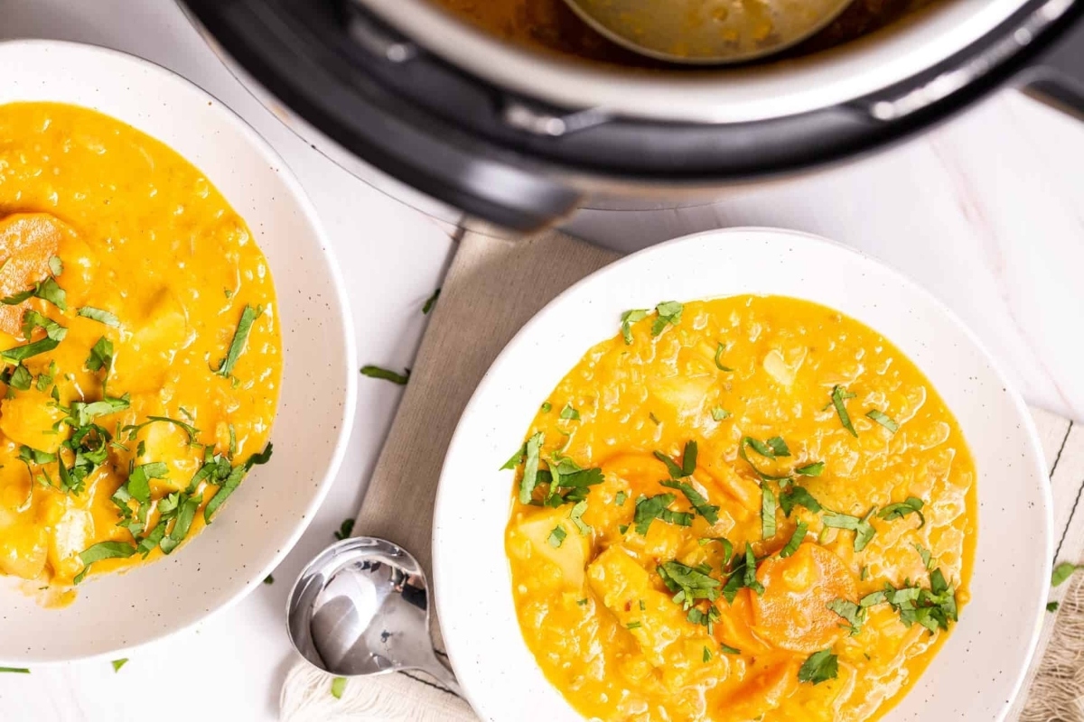 Two bowls of soup in front of an Instant Pot, perfect for cozy dinners.