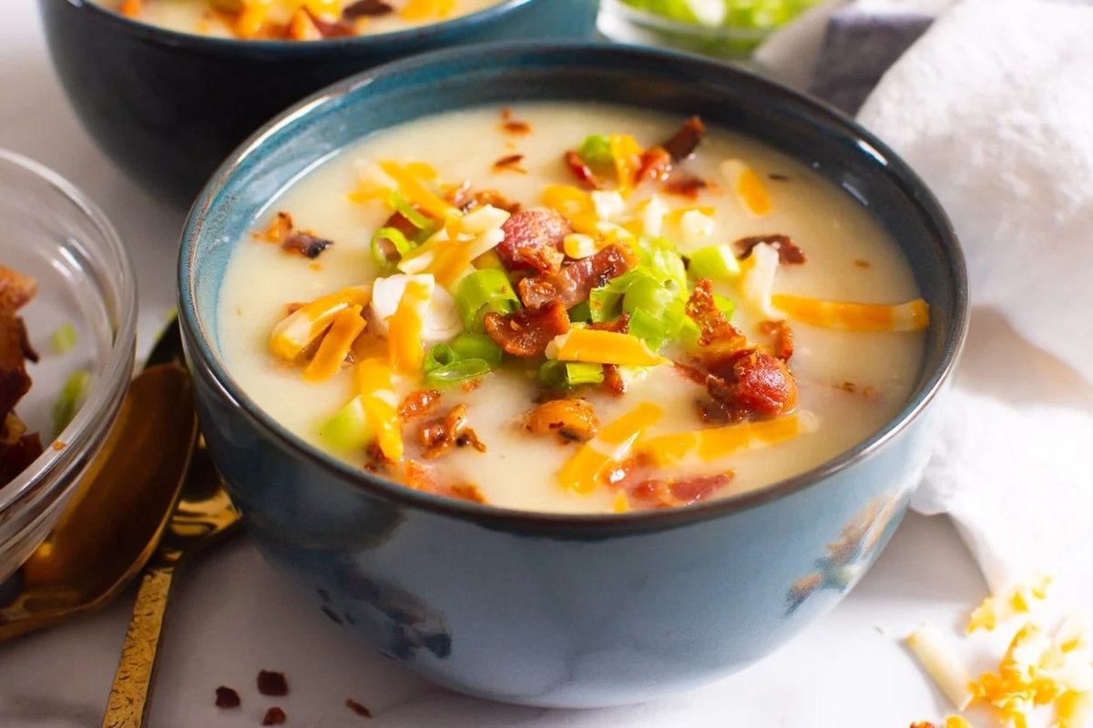 Two bowls of cheesy potato soup.