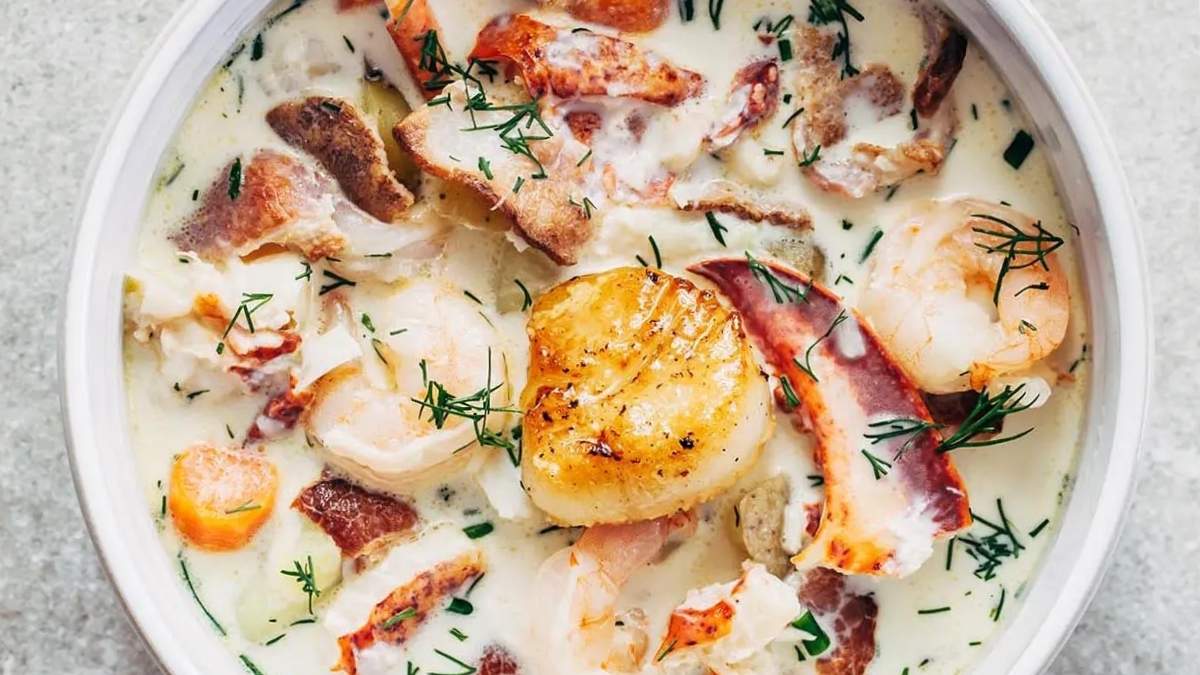 A white bowl of soup with shrimp, potatoes and dill. This recipe combines succulent shrimp, tender potatoes, and aromatic dill to create a delicious and comforting soup.
