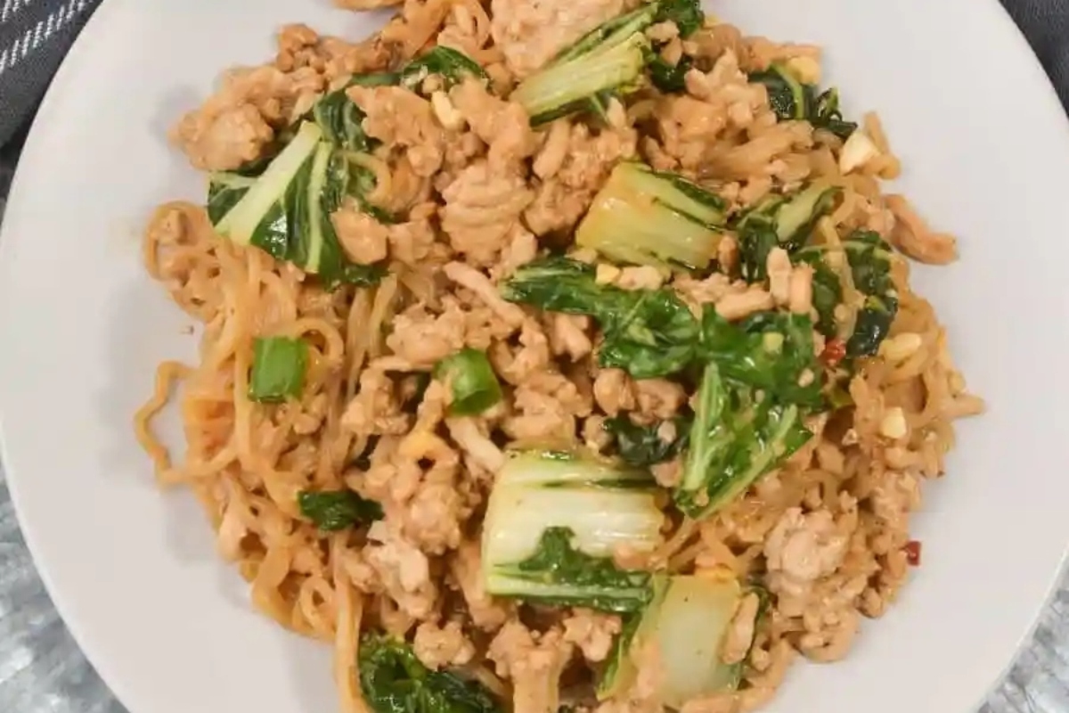 A low carb dinner plate of noodles with chicken and greens on it.