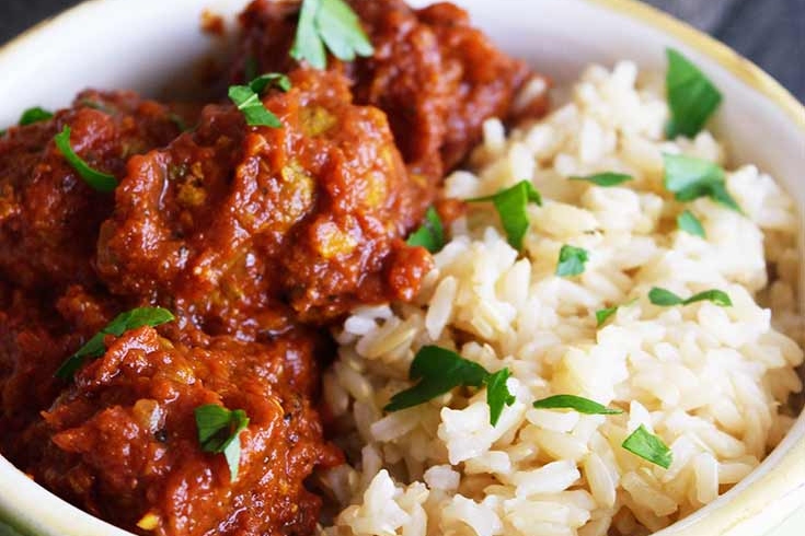 Curry meatballs and rice in a bowl.