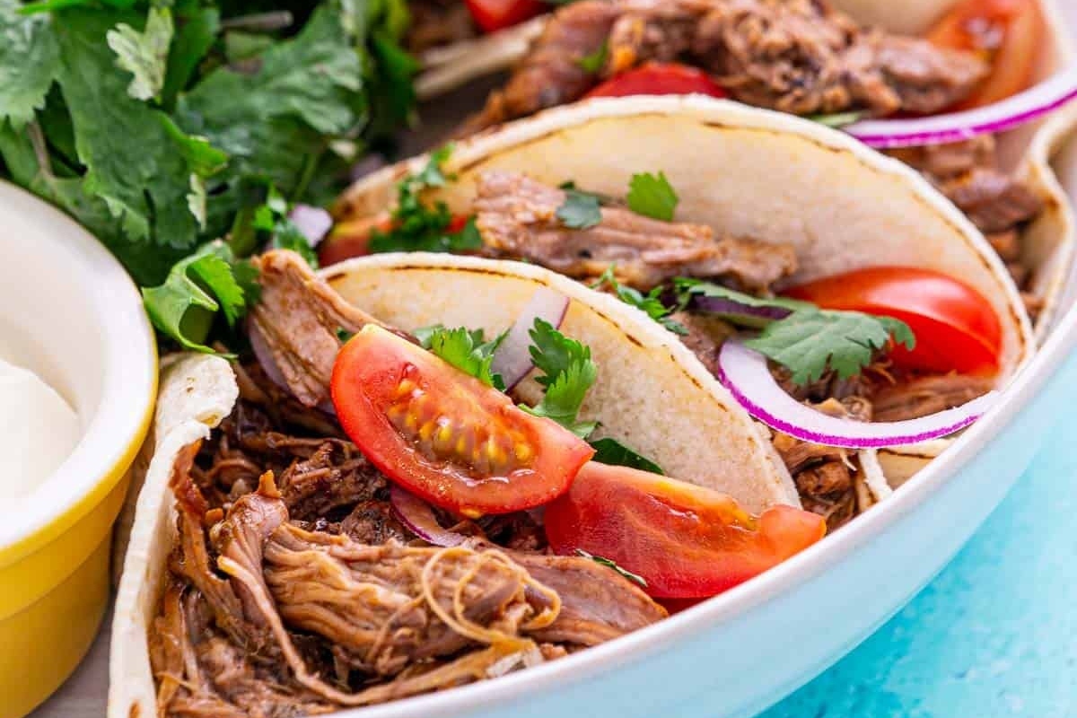 Pulled pork tacos with sour cream and tomatoes for a delicious Taco Night dinner.