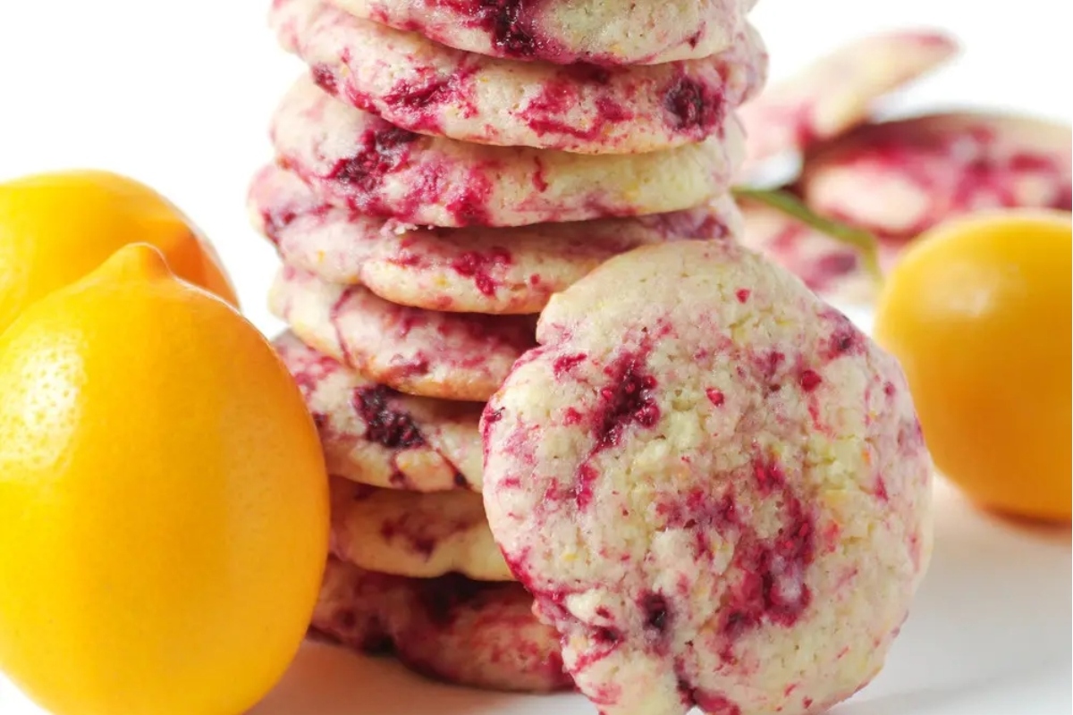 A stack of Valentine's Day cookies with lemons and raspberries.