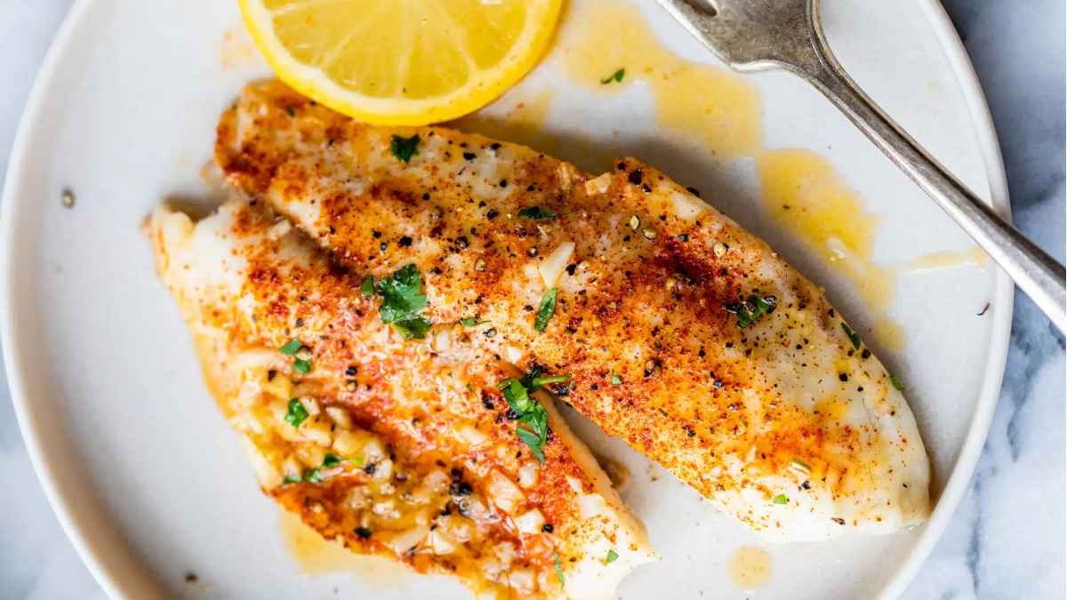 Lemon butter tilapia on a plate.