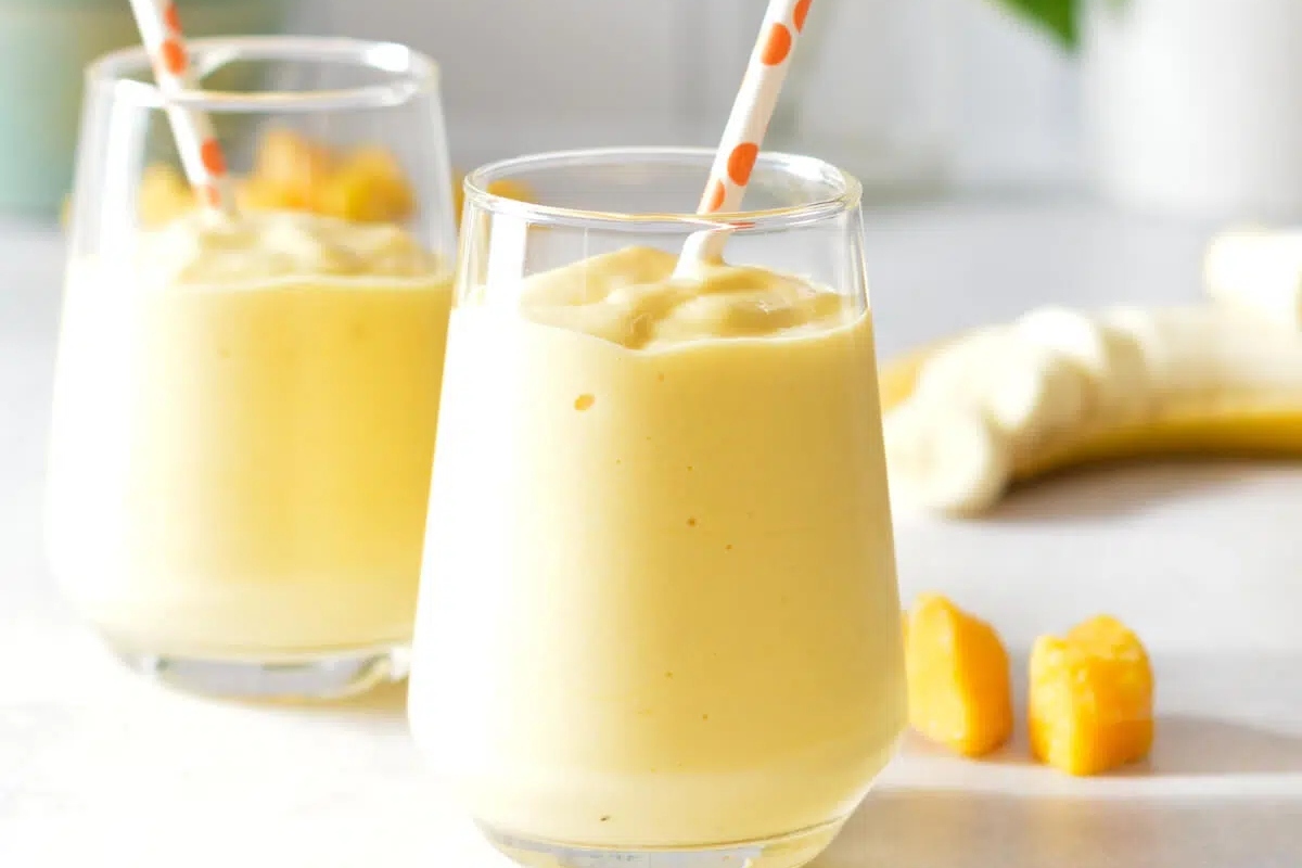 Two glasses of healthy smoothie with bananas, perfect for breakfast.