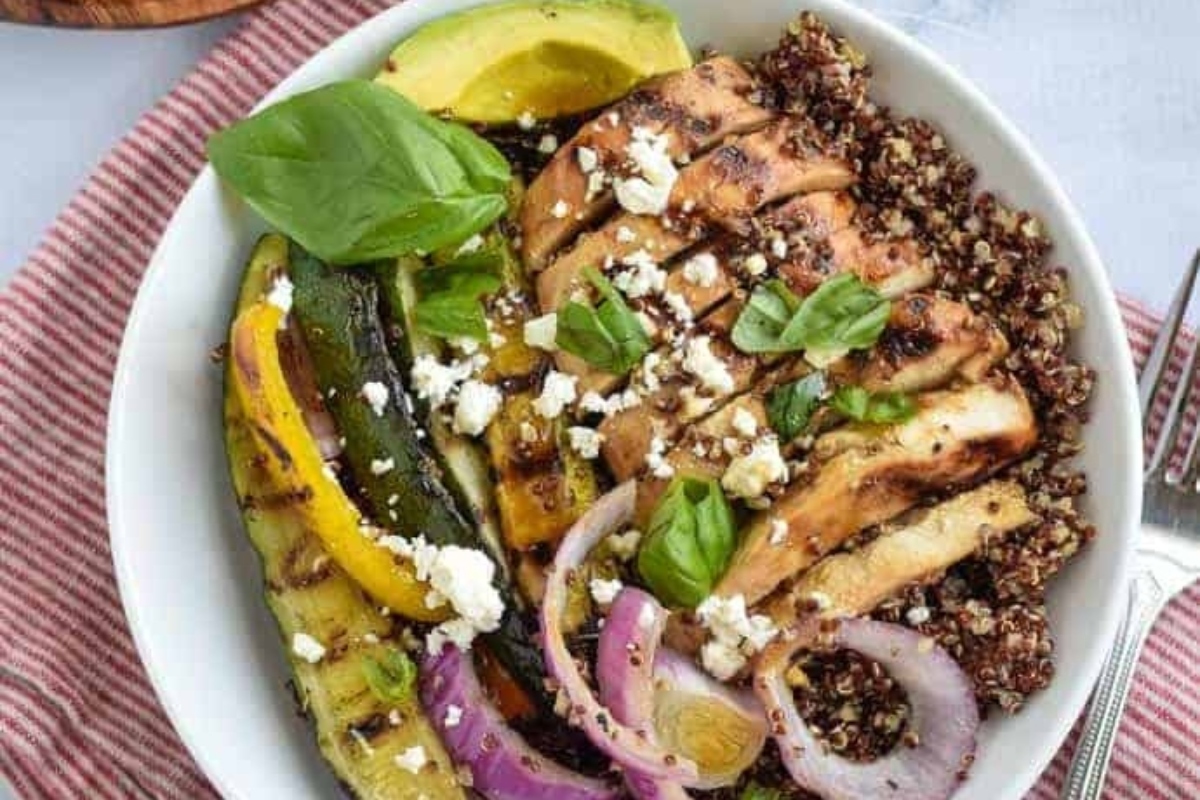 A grain bowl with chicken, vegetables and quinoa.