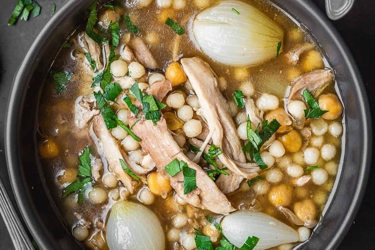 A hearty bowl of chicken and chickpea stew with onions and garlic.