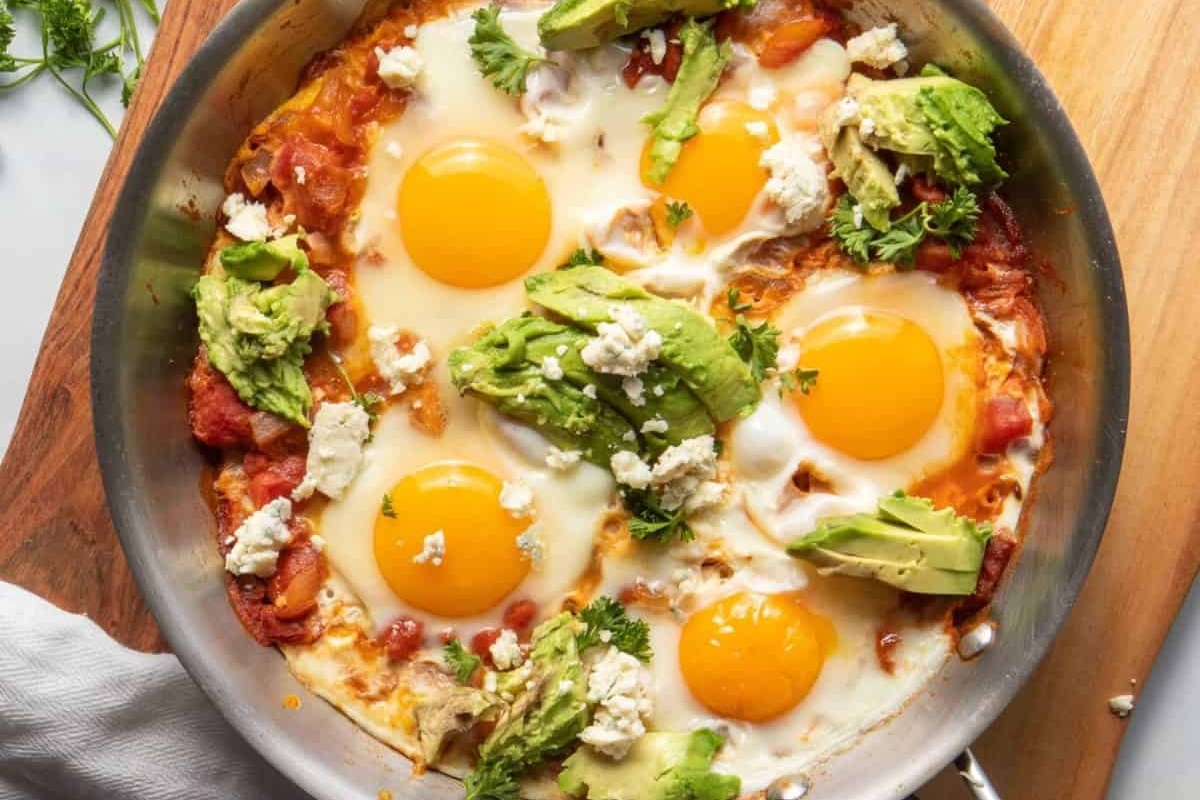 A delicious breakfast skillet with eggs, avocado, and tomatoes.
