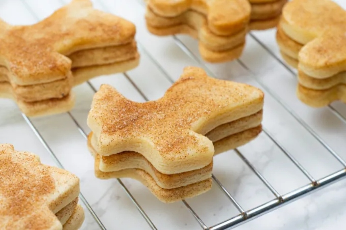 A stack of delicious cinnamon sugar cookies on a cooling rack, perfect for Christmas desserts.