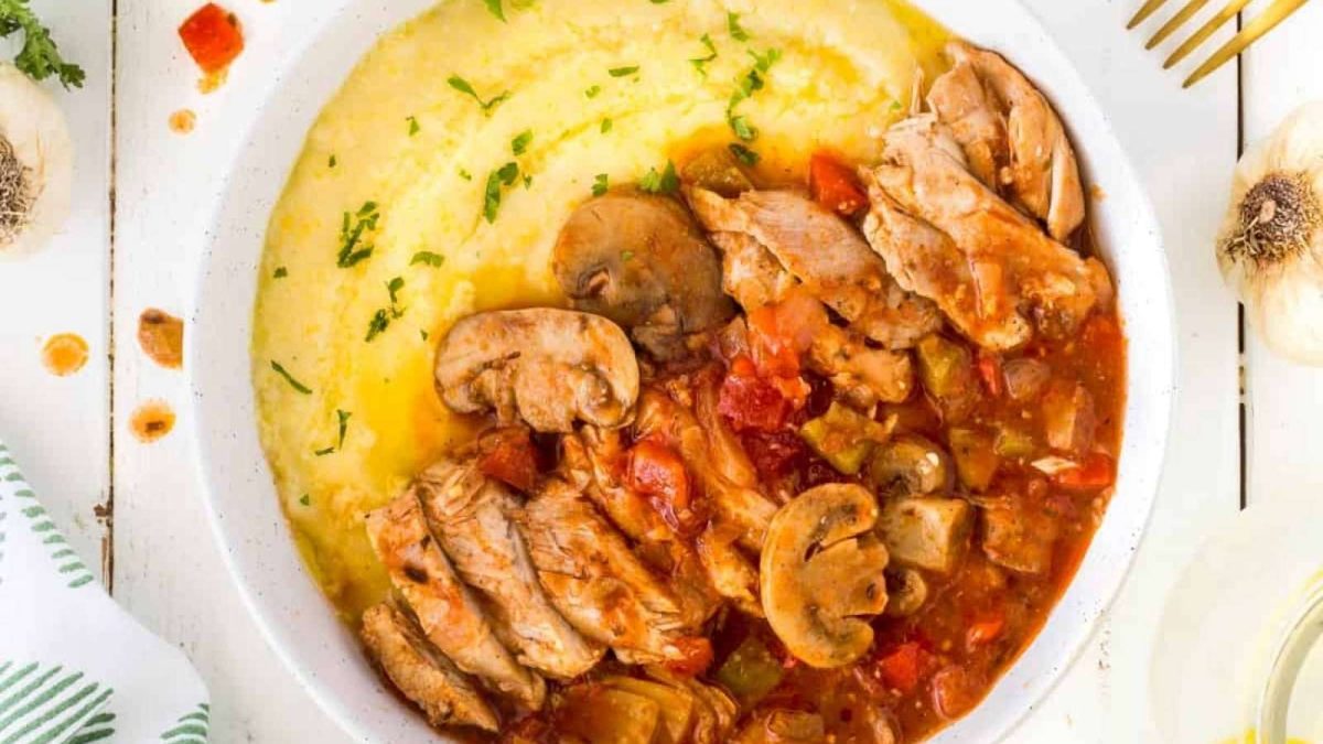 A bowl of food with meat and vegetables.