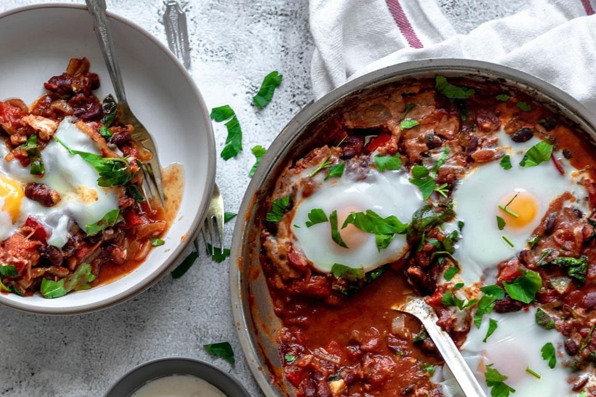 Two pans with eggs and beans in them, perfect for recipes with spinach.