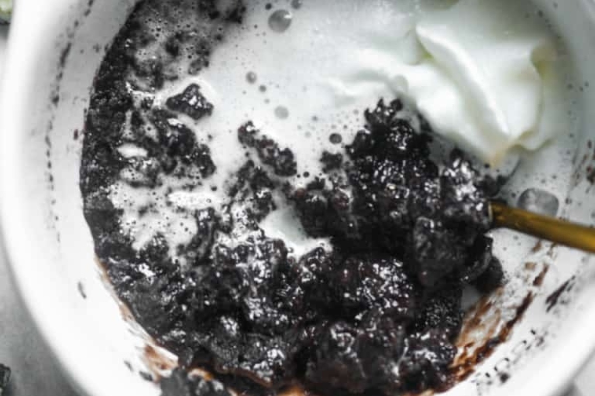 A mug cake with whipped cream on top.