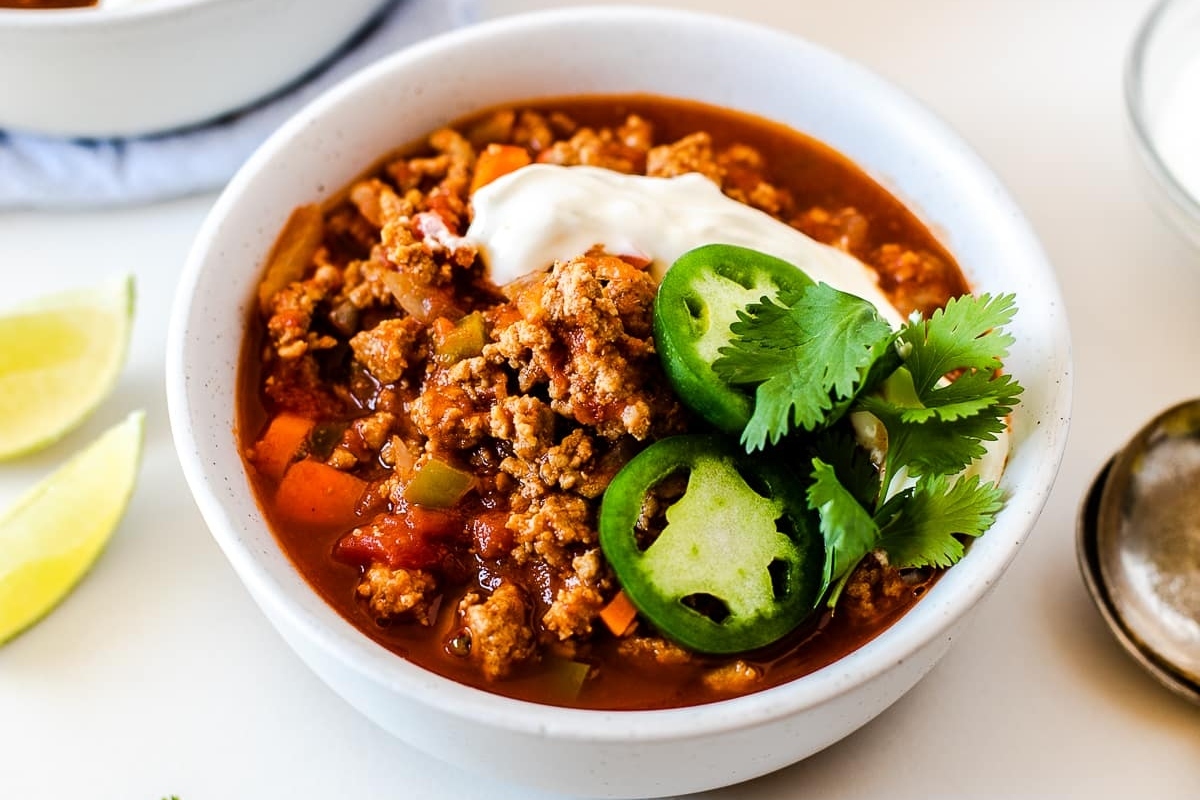 Discover a delicious bowl of chili enhanced with the tang of sour cream and lime.