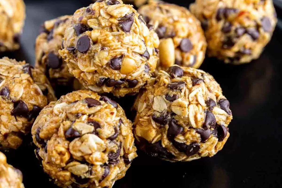 A plate of healthy chocolate chip cookie dough balls on a black plate.