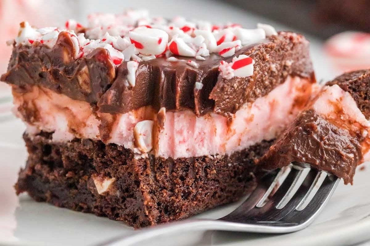A slice of chocolate peppermint cake on a plate with a fork. The recipe for this delectable dessert includes the refreshing flavor of peppermint.
