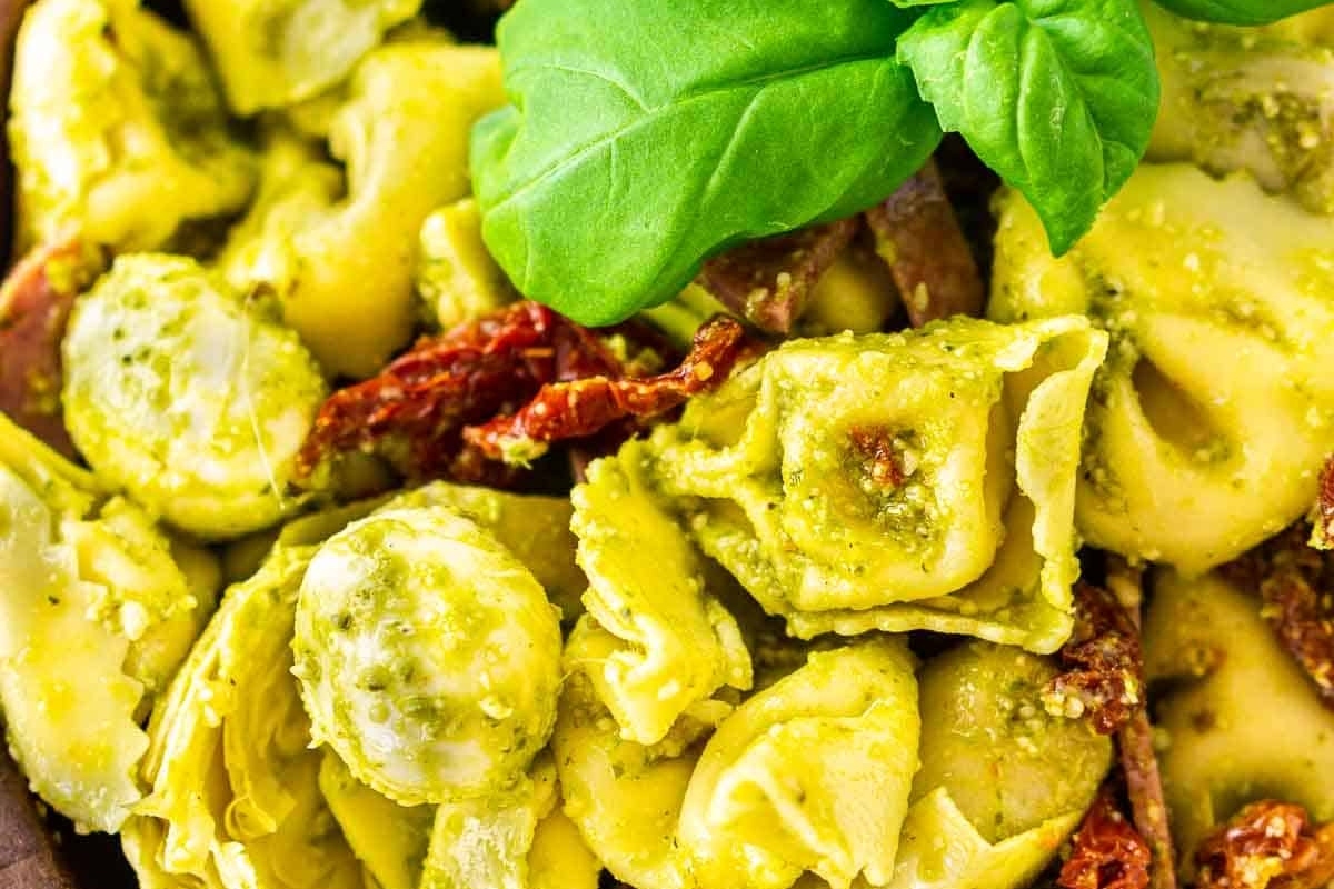 A delicious recipe of tortellini with pesto and basil.