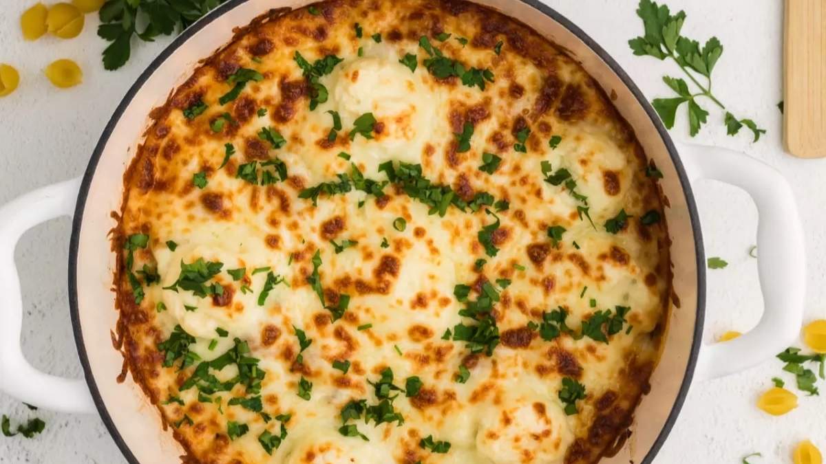 Cheesy comfort food pasta in a white dish with parmesan cheese and parsley.