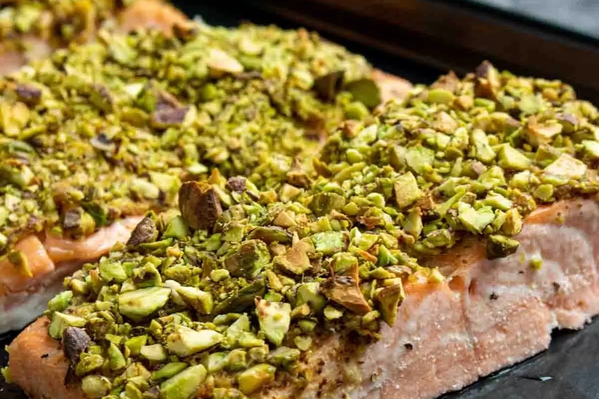 Elegant salmon with pistachios on a baking sheet.