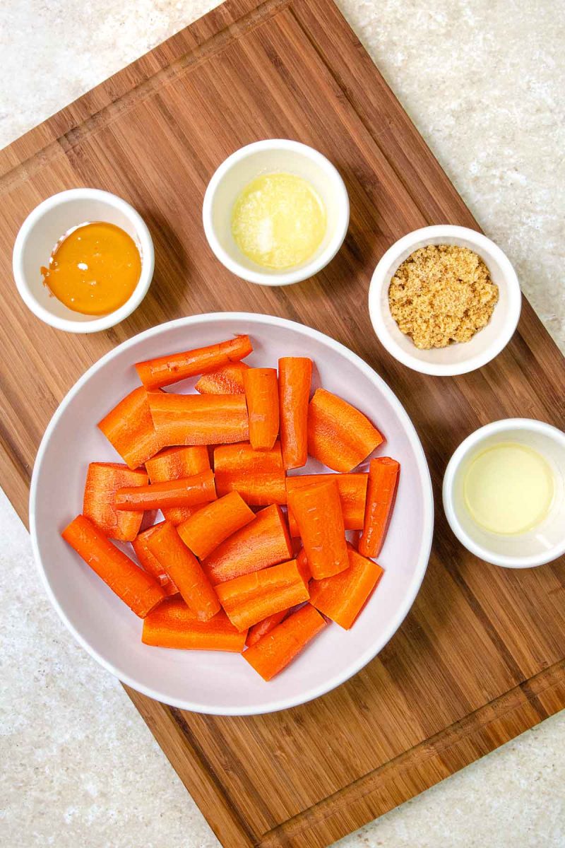A wooden cutting board with air fryer carrots on it.