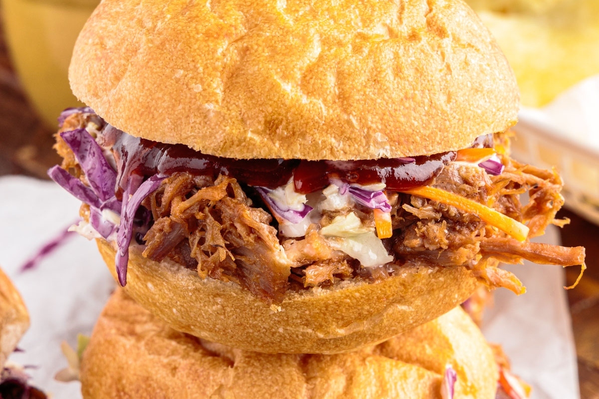 A stack of pulled pork sliders with coleslaw on top, perfect for game day.