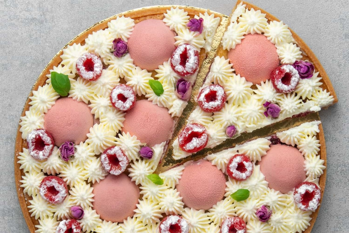 A tart pizza with strawberries and raspberries on top.