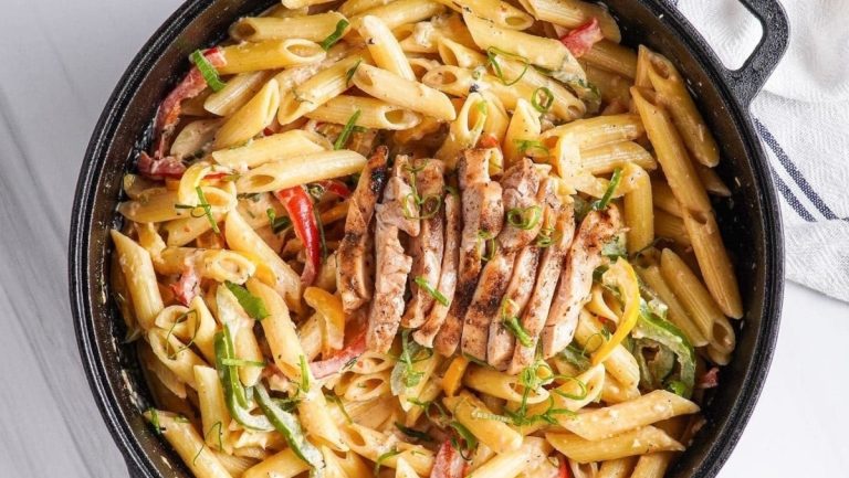 An inexpensive family dinner, filled with love, featuring a skillet full of pasta with chicken and vegetables.