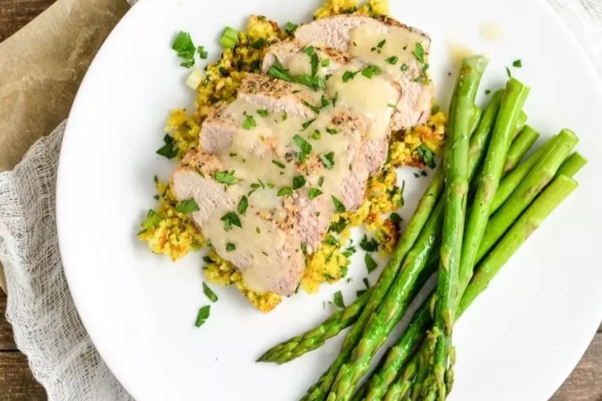 Winter dinner of pork tenderloin and asparagus on a white plate.