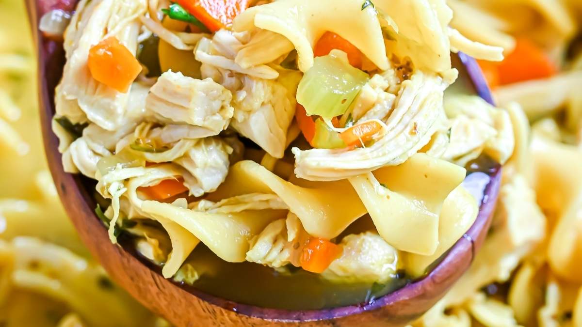 This shared round-up showcases a delicious chicken noodle soup recipe served in a wooden spoon.