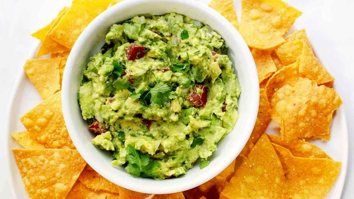 Salsa guacamole with nachos on the side.