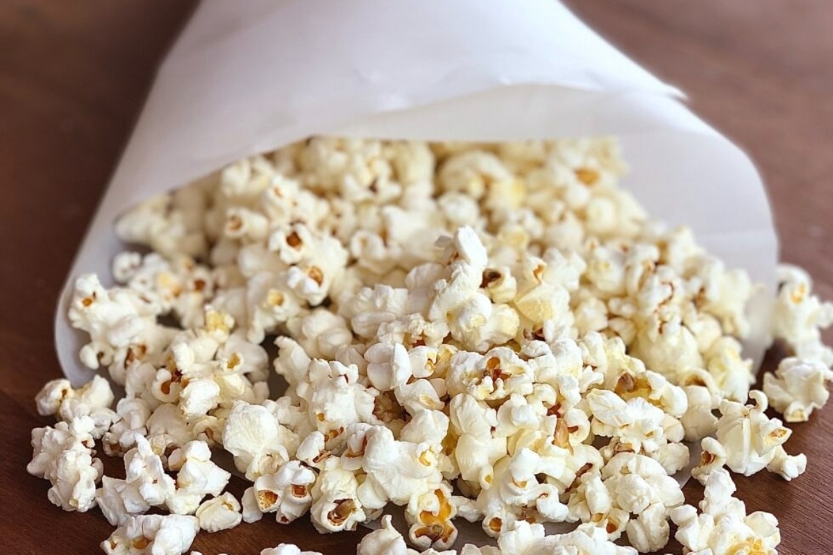 Truffle oil-infused popcorn in a paper bag on a wooden table.