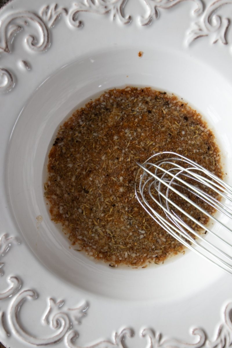 A white bowl with a whisk in it, perfect for preparing air fryer mushrooms.
