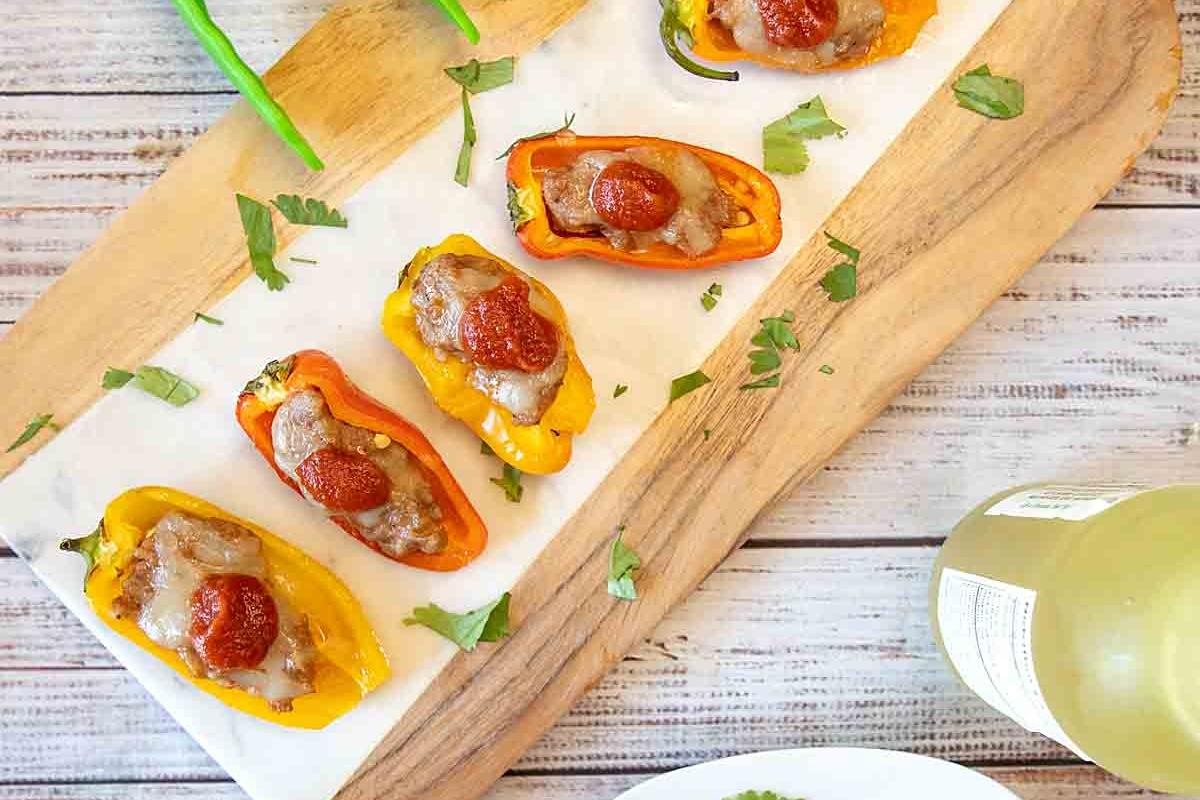 Bite-sized stuffed peppers on a cutting board.